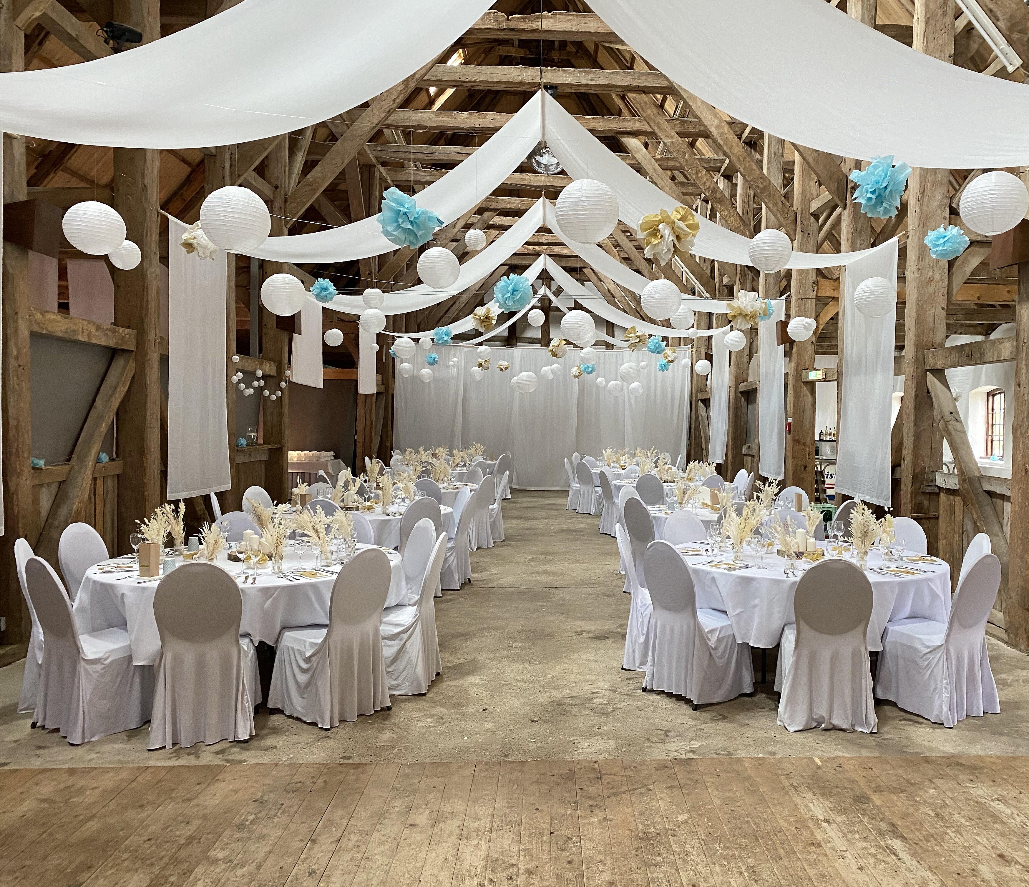 Gedeckte Tische bei einer Hochzeit in der historischen Scheune